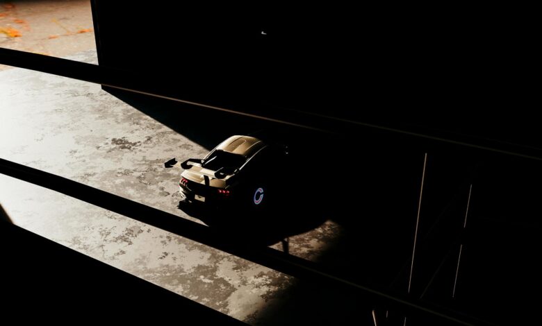 Luxury sports car in shadows of a modern garage space.