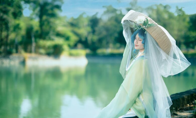 A serene portrait of a cosplayer in traditional attire by a lake in Vietnam.