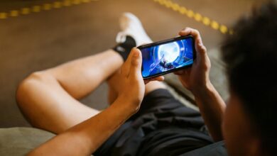 Man playing a video game on a smartphone while sitting comfortably indoors.