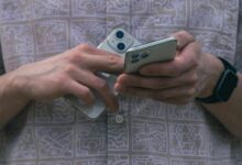 Detail of hands holding two smartphones, showcasing modern technology usage.