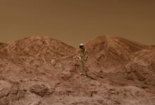 Astronaut in spacesuit explores barren, Mars-like desert terrain under brown sky.