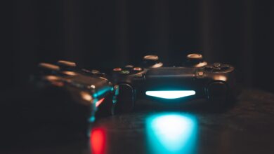 Close-up of glowing gaming controllers on a dark surface, creating a moody ambiance.