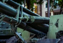 Detailed view of military artillery equipment displayed outdoors in a museum setting.