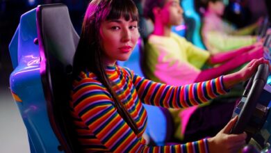 Teenagers immersed in a vivid arcade setting, focused on racing games.