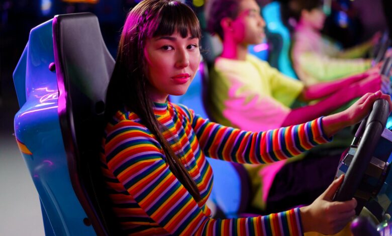 Teenagers immersed in a vivid arcade setting, focused on racing games.