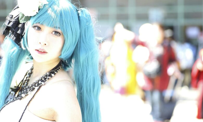 Vibrant cosplay portrait of a woman with blue hair and intricate costume in bright outdoor setting.