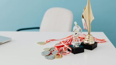 A collection of trophies and medals displayed on a white desk, symbolizing success and victory.