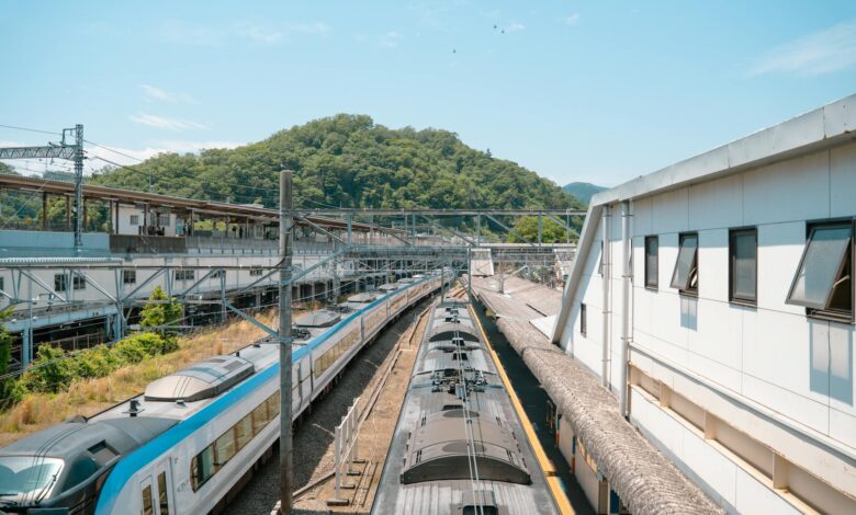 Overhead view of a bustling train station in Hachiōji, Tokyo during a sunny day.