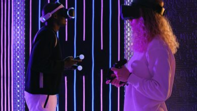 Two adults enjoying virtual reality gaming in a vivid neon-lit room for an immersive experience.