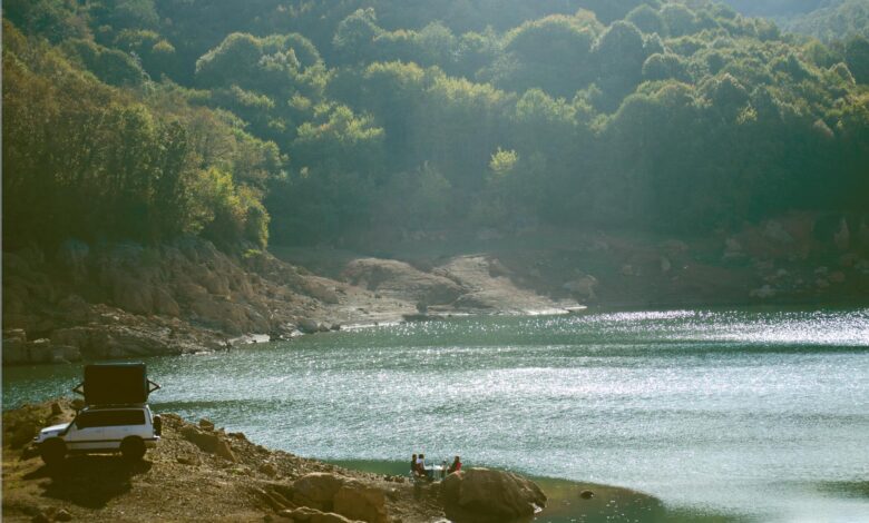 Tranquil campsite by the lake in a mountain forest, perfect for outdoor adventure.