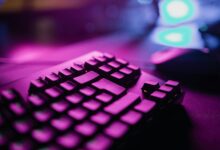 A close-up view of an RGB backlit gaming keyboard with a vibrant purple glow, perfect for tech and gaming enthusiasts.