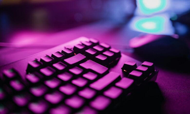 A close-up view of an RGB backlit gaming keyboard with a vibrant purple glow, perfect for tech and gaming enthusiasts.