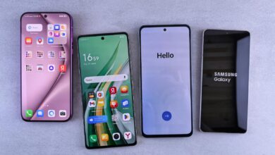 Four modern smartphones showcasing home screens, applications, and startup logos on a sleek surface.