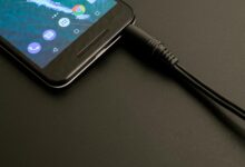 Close-up of a smartphone being charged, displaying a modern interface on a dark backdrop.