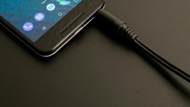 Close-up of a smartphone being charged, displaying a modern interface on a dark backdrop.
