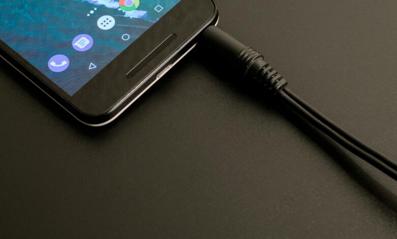 Close-up of a smartphone being charged, displaying a modern interface on a dark backdrop.