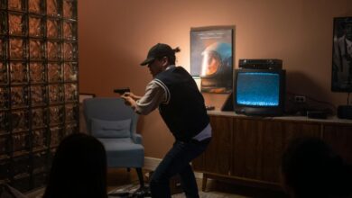 Teens creatively engage in play, pretending to be in a suspenseful movie scene indoors.