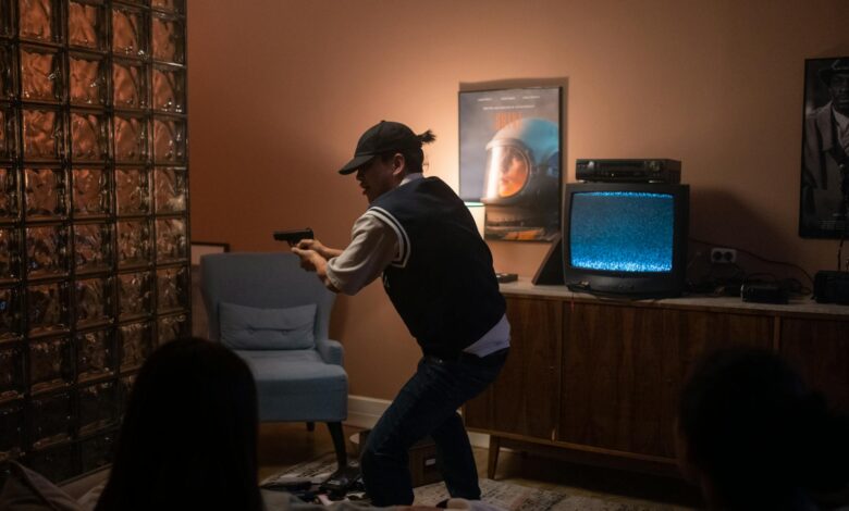 Teens creatively engage in play, pretending to be in a suspenseful movie scene indoors.