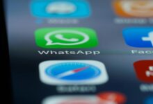 Detailed close-up of a smartphone's home screen displaying popular applications like WhatsApp.
