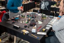Players engaged in a tabletop miniature game tournament in Zagreb, showcasing strategy and teamwork.