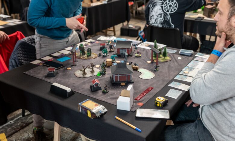 Players engaged in a tabletop miniature game tournament in Zagreb, showcasing strategy and teamwork.