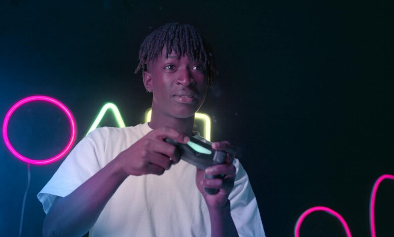 Serious young man playing video games in a neon-lit environment, focused and immersed.