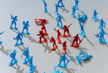 Red and blue toy soldiers on a light surface forming a strategic battle scene.