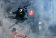 Two cosplayers enact a thrilling martial arts battle immersed in foggy atmosphere.