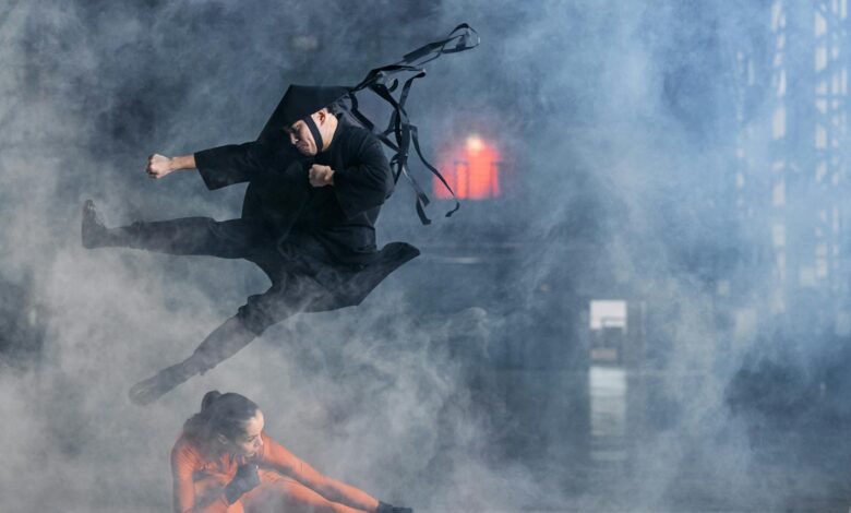 Two cosplayers enact a thrilling martial arts battle immersed in foggy atmosphere.