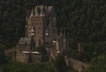 Explore the stunning medieval Eltz Castle nestled among lush green trees, captured from above.