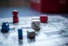 Close-up view of board game pieces and dice on a game board. Perfect for recreation and strategy themes.