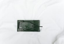 Green toy tank viewed from above on a white surface, emphasizing playtime and imagination.