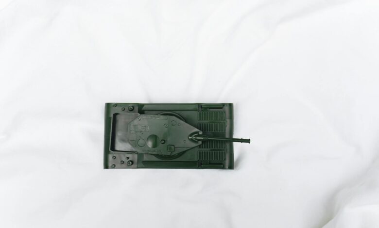 Green toy tank viewed from above on a white surface, emphasizing playtime and imagination.