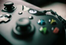 Detailed view of a black gaming controller showcasing its sleek design and colorful buttons.