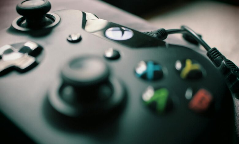 Detailed view of a black gaming controller showcasing its sleek design and colorful buttons.