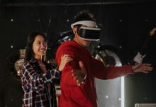 Young couple engaging in VR gaming indoors, wearing a virtual reality headset.