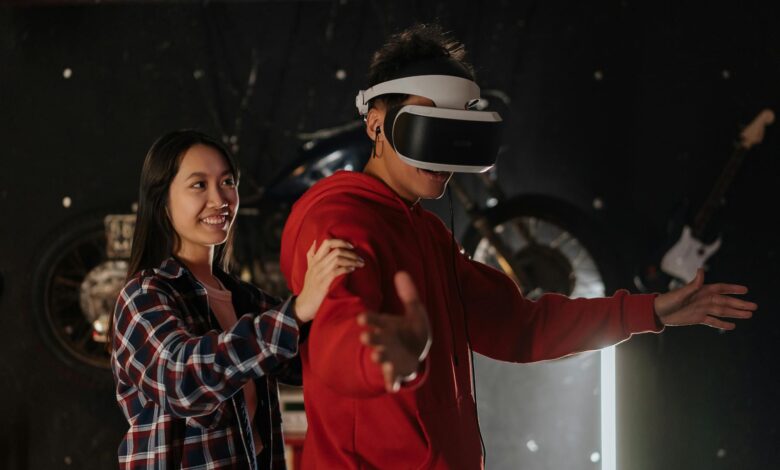 Young couple engaging in VR gaming indoors, wearing a virtual reality headset.