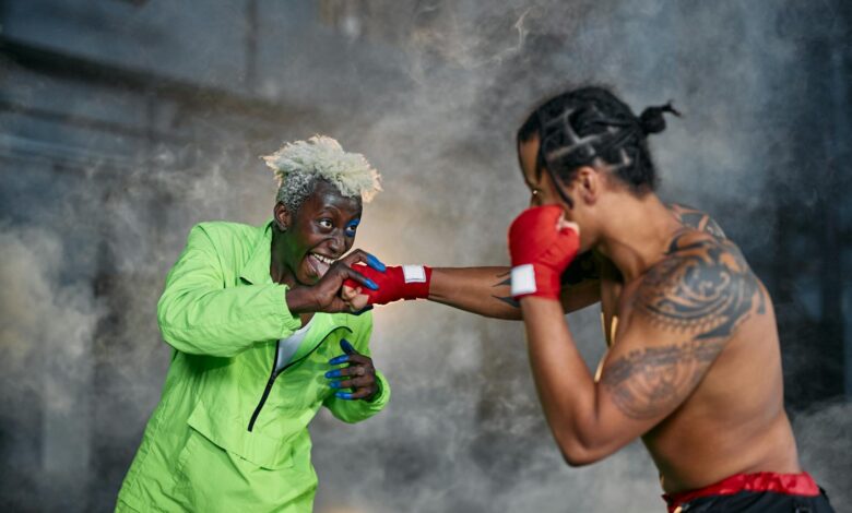 Intense moment of two cosplayers engaged in a dramatic fighting scene.