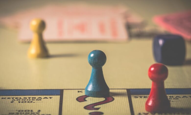 Close-up of a classic board game with vibrant tokens and dice on a playing board.