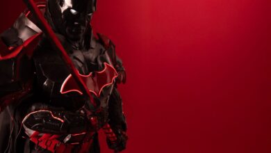 Striking image of a Batman cosplay with a red background, exuding power and mystery.