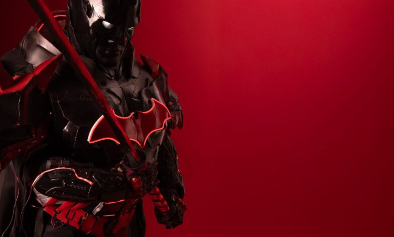 Striking image of a Batman cosplay with a red background, exuding power and mystery.