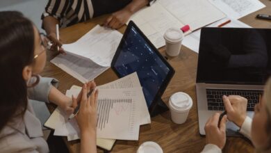 Business team collaborating with laptops and documents in a meeting, showcasing teamwork and cooperation.