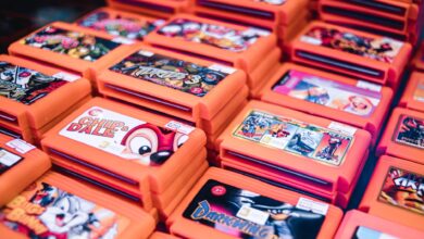 Close-up of stacked retro video game cartridges in orange cases, showcasing popular titles.