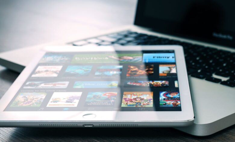 Tablet displaying streaming services on a laptop, illustrating digital entertainment setup.