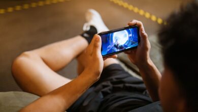 Man playing a video game on a smartphone while sitting comfortably indoors.