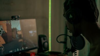 Focused gamer with headset playing a video game on a desktop computer indoors.
