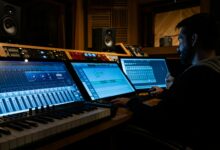 Side view of concentrated young male musician working on computer in studio while composing new song