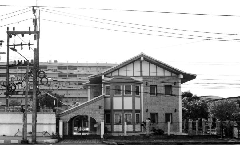 Black and white photo of a brick house with electric cables in Hat Yai, Thailand.