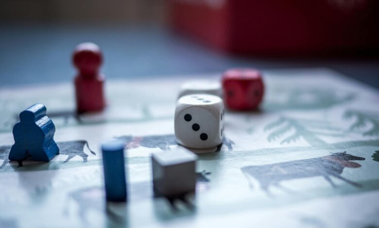 Close-up view of board game pieces and dice on a game board. Perfect for recreation and strategy themes.