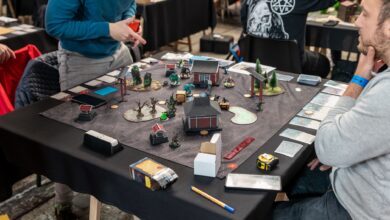 Players engaged in a tabletop miniature game tournament in Zagreb, showcasing strategy and teamwork.
